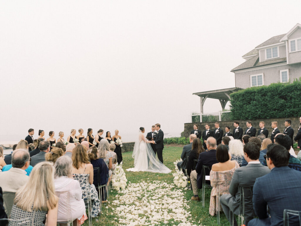 Bride and groom exchanging vows at foggy Wychmere Beach Club ceremony