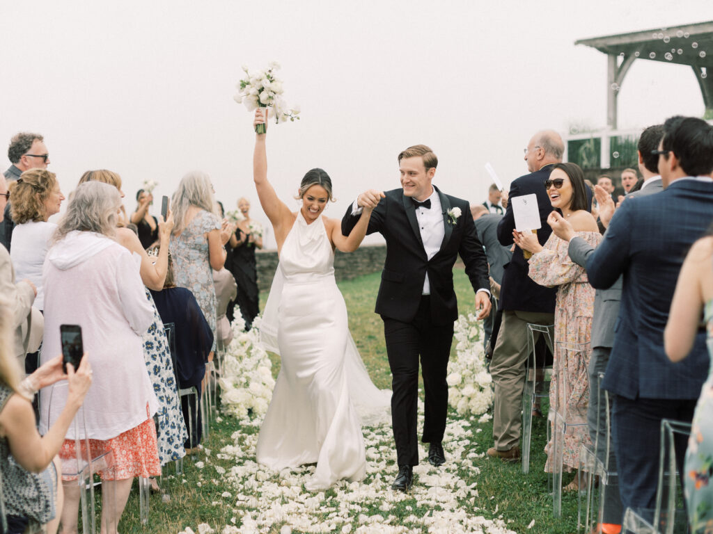 Bride and groom walk down the aisle surrounded by guests at Wychmere Beach Club wedding