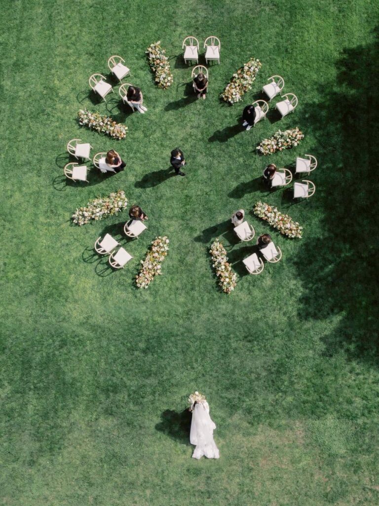 Overhead view of outdoor wedding ceremony with circular seating and floral aisle at Glen Manor House