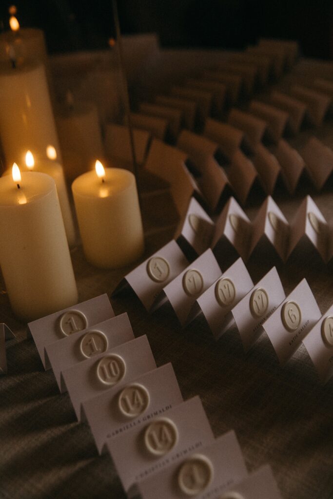 Tented escort cards with white wax seals and table numbers for an elegant black and white wedding
